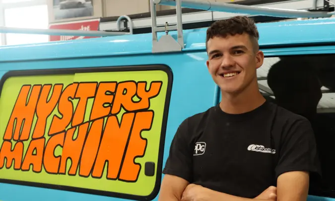 Ben Morrison at work, standing in front of a van with Mystery Machine sign writing.