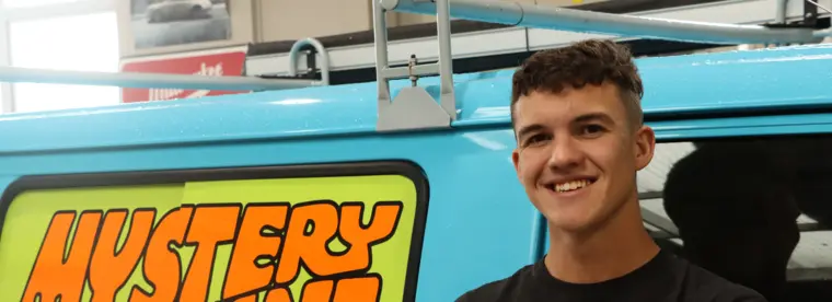 Ben Morrison at work, standing in front of a van with Mystery Machine sign writing.